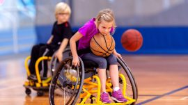 Niña jugando a baloncesto en silla de ruedas