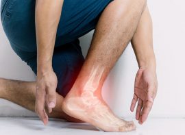 Persona agachada con dolor en el tobillo
